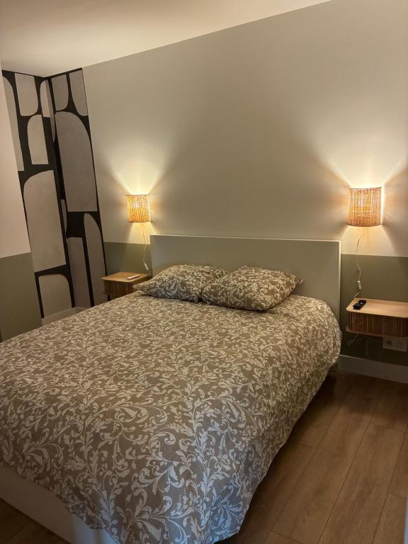 a bedroom with a bed and two lamps on two tables at Chez nous Mulhouse - Hyper Centre - Parking - Balcon - Netflix in Mulhouse