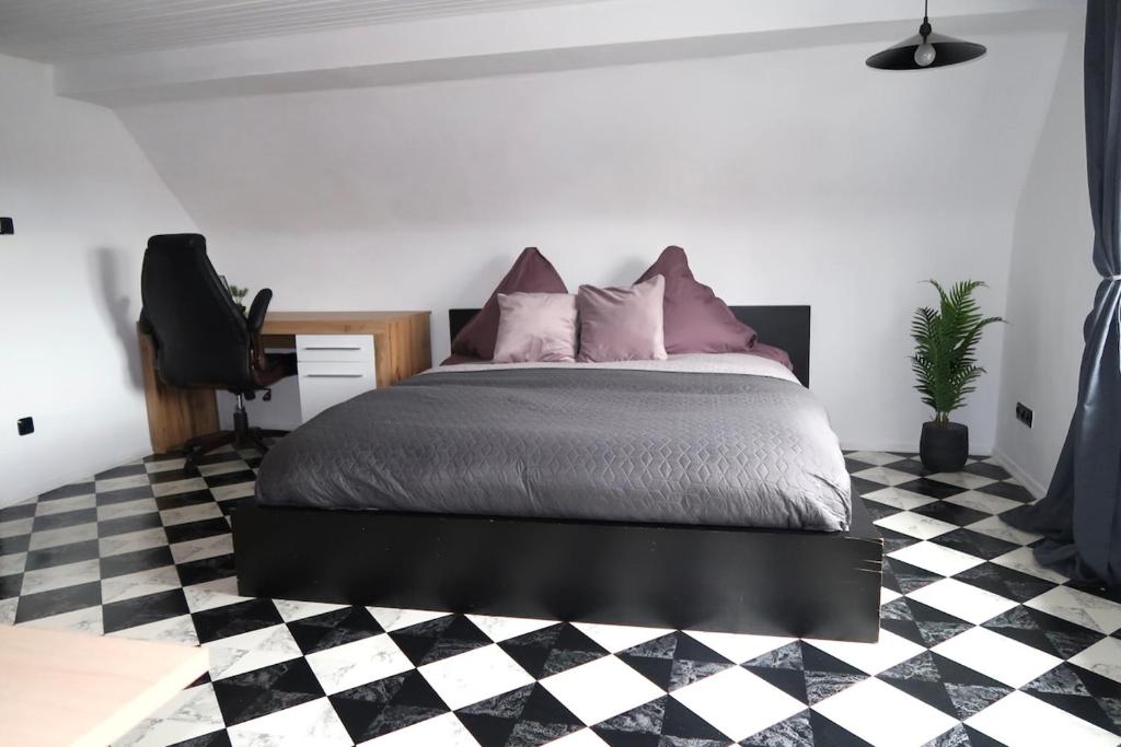 a bedroom with a bed and a black and white checkered floor at Cozy room with bathroom in a private house in Bergrheinfeld