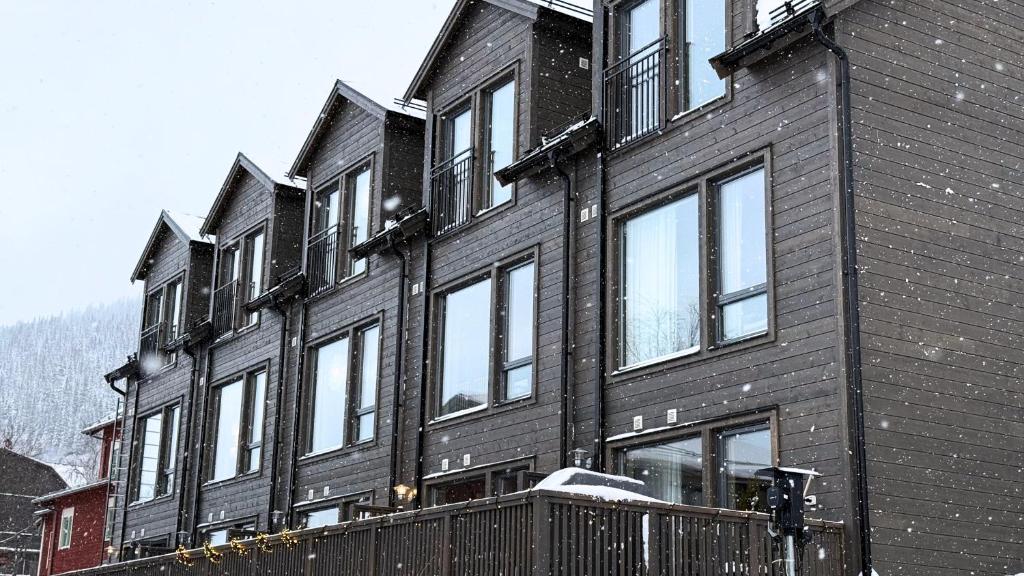 a black building with snow on the windows at Alpine Townhouse - Åre Valley Lodges in Åre
