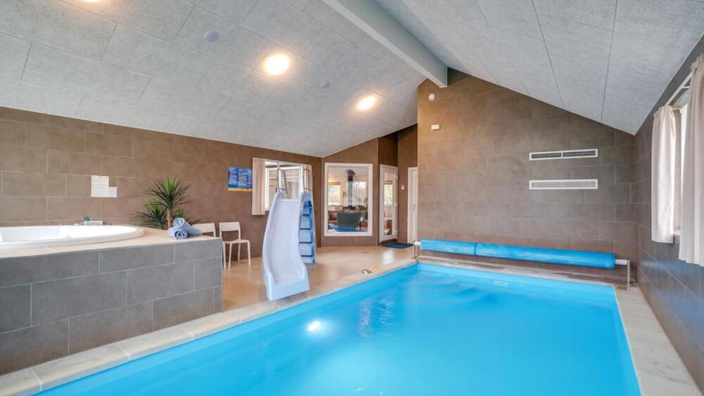a swimming pool in a bathroom with a tub and a sink at Villavilla 474 - Grenå Strand, Østjylland in Grenå