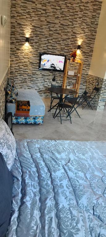 a bedroom with a bed and a table and a television at DAR LAAZIZA in Meknès