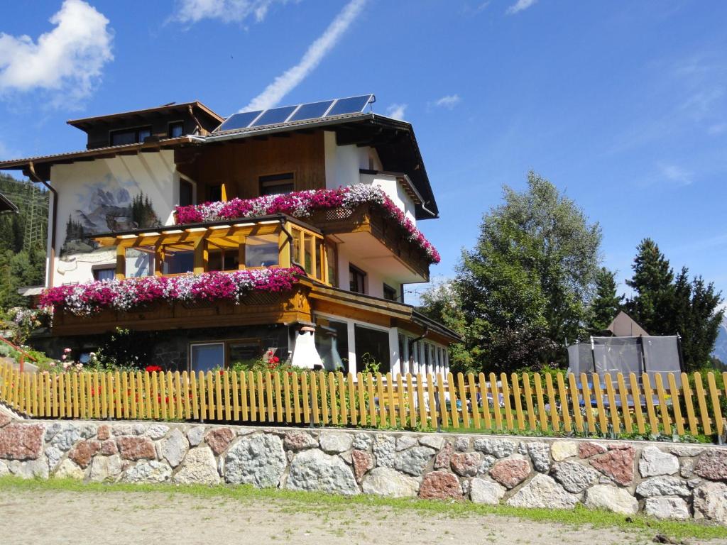 a house with a yellow fence and flowers at Haus Hochzeigerblick in Wenns