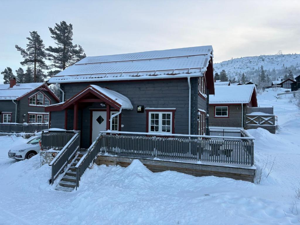 a house is covered in snow with a snow covered porch at Fjällstuga Vemdalsskalet in Vemdalen