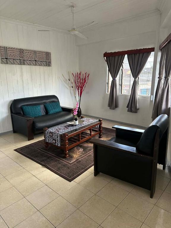 a living room with two couches and a coffee table at YaNuYaNu Appartment Nabua in Suva