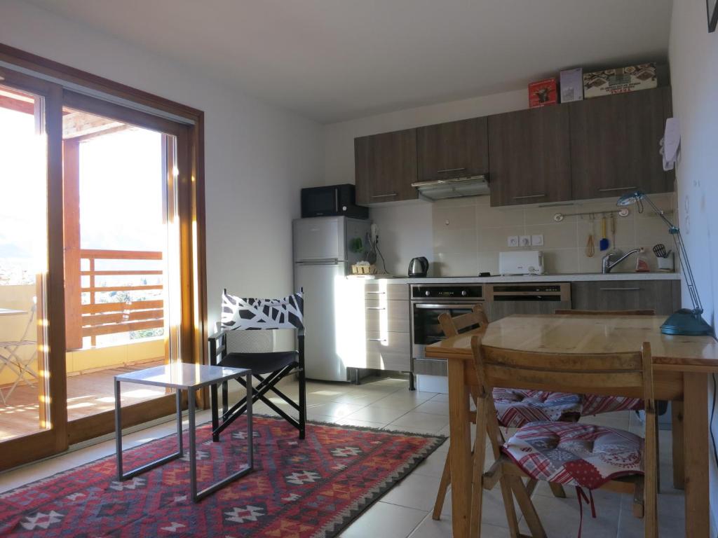 a kitchen with a table and a kitchen with a balcony at Les Allobroges C03 in Guillestre