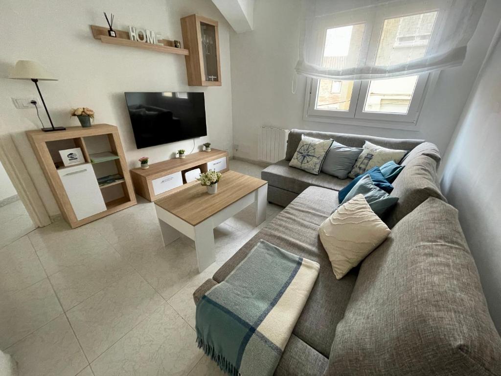 a living room with a couch and a tv at El Orbayín de Llastres in Lastres