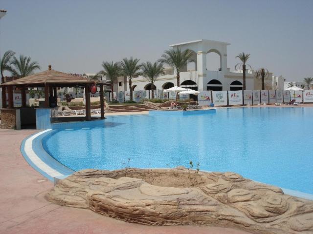 a large blue swimming pool in a resort at Alma & Thiago House in Sharm El Sheikh