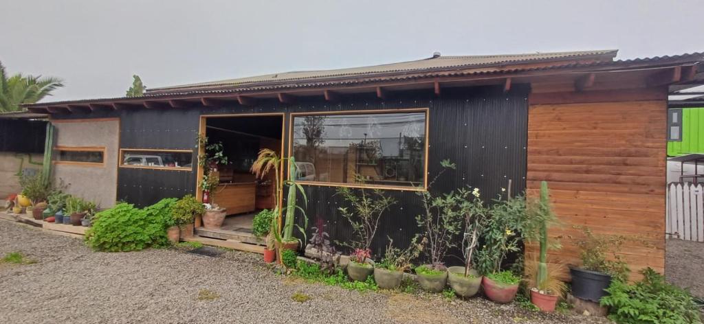 a house with a large window and some plants at Hostal Arboretum cafeteria & jardin in Hijuelas