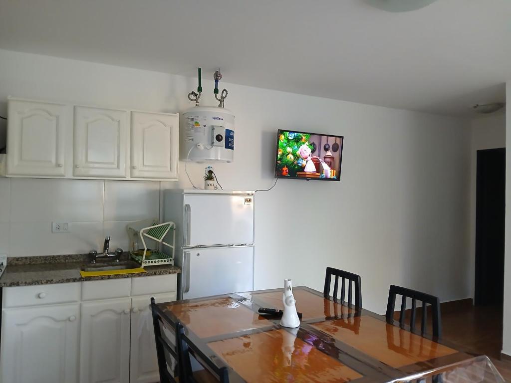 eine Küche mit einem Tisch und einem weißen Kühlschrank in der Unterkunft La isabela in Mar del Plata