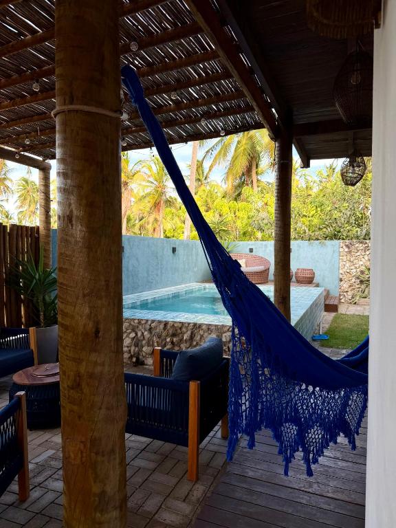 a hammock on a patio next to a swimming pool at Maré House in Amontada