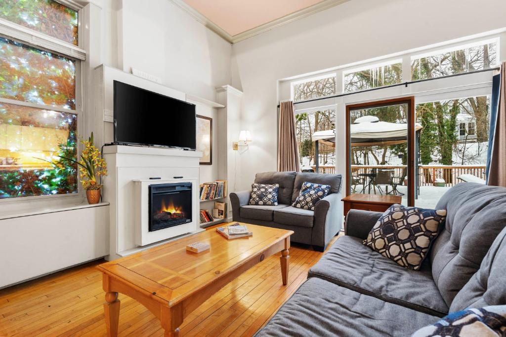 a living room with a couch and a fireplace at Historic Loft w/ Private Deck, 2 Blocks to Dtwn in Saugatuck