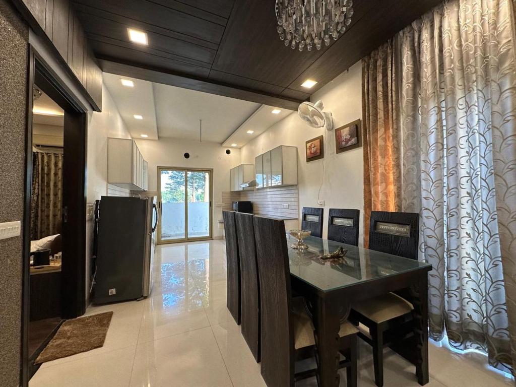a kitchen with a dining table and a refrigerator at Joyous stay in Jaipur