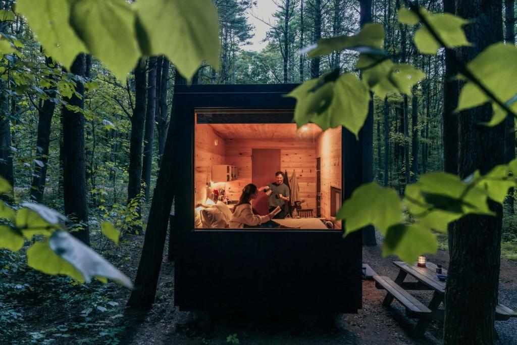 a couple sitting in a tiny house in the woods at Postcard Cabins Brazos Valley, Outdoor Collection by Marriott Bonvoy in Navasota