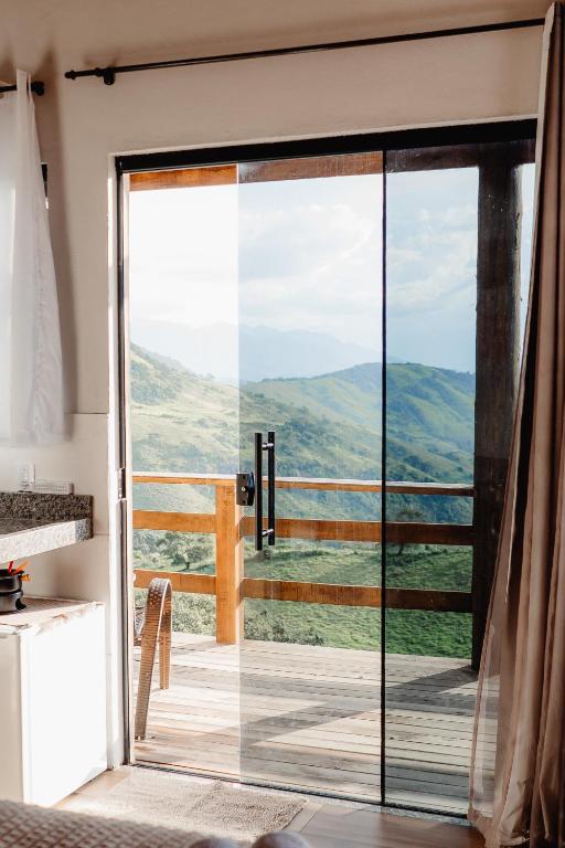 a room with a sliding glass door with a view at Chalé Romântico em Itamonte-MG in Itamonte