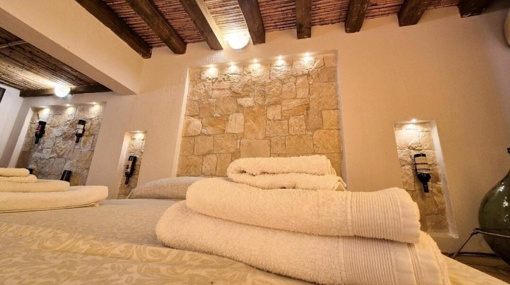 a room with three beds with towels on them at Borgo Antico - Barrique Studio in Lotzorai