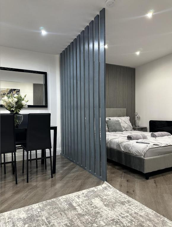 a bedroom with a bed and a dining room with a table at Studio T in Dagenham