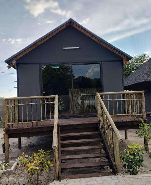 a house with a large window and a wooden staircase at Sofitel Inn in Maun