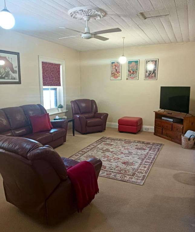 a living room with a couch and a flat screen tv at Woodhill Way Burra in Burra