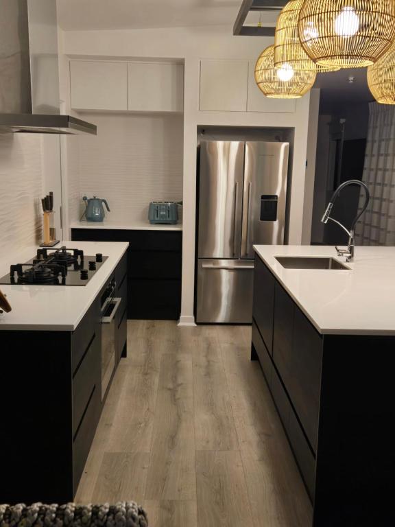 a kitchen with a stainless steel refrigerator and white cabinets at Pakawau Princess in Pakawau