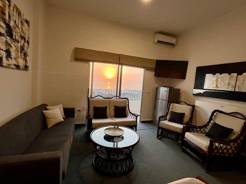 a living room with a couch and chairs and a table at Tabarja Chalet Studio Sea & Mountain View in An Nā‘ūrah