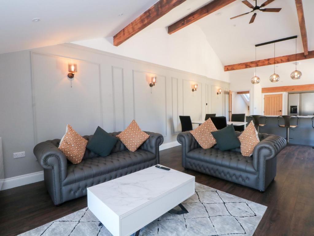 a living room with couches and a table at The Penthouse at 86 in Rossendale