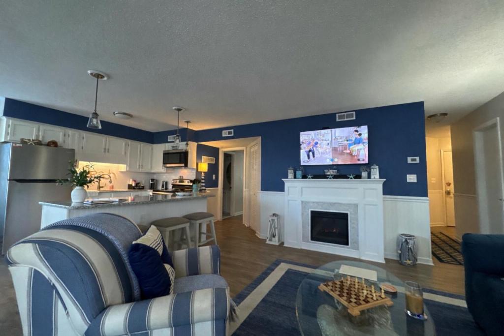 a living room with a couch and a tv on a wall at Golf Glenn Villa A205 in Myrtle Beach