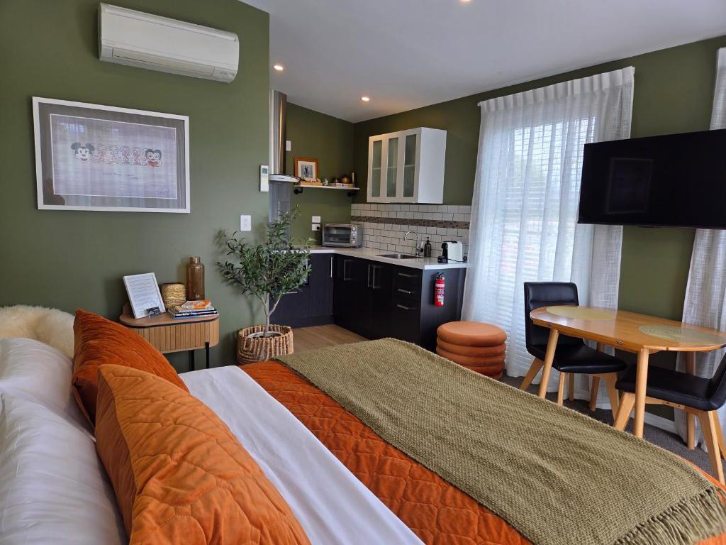 a bedroom with a bed and a kitchen with a table at “No.25”Stand alone guest studio unit in Twizel