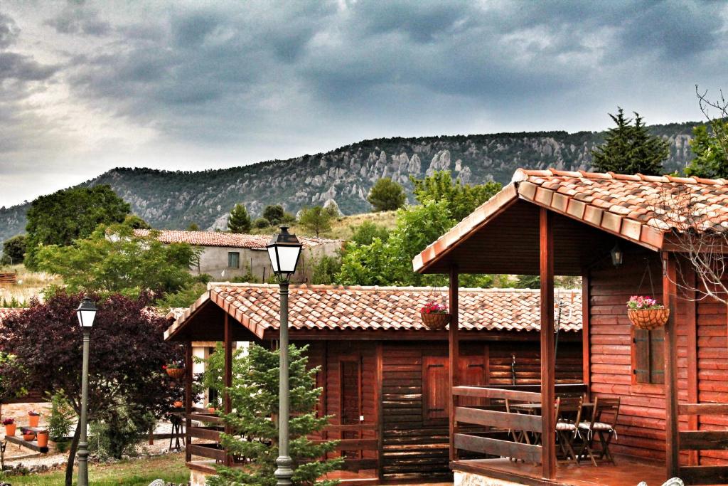 a log cabin with a table and chairs in front of it at Fuente Del Arca in Cañamares