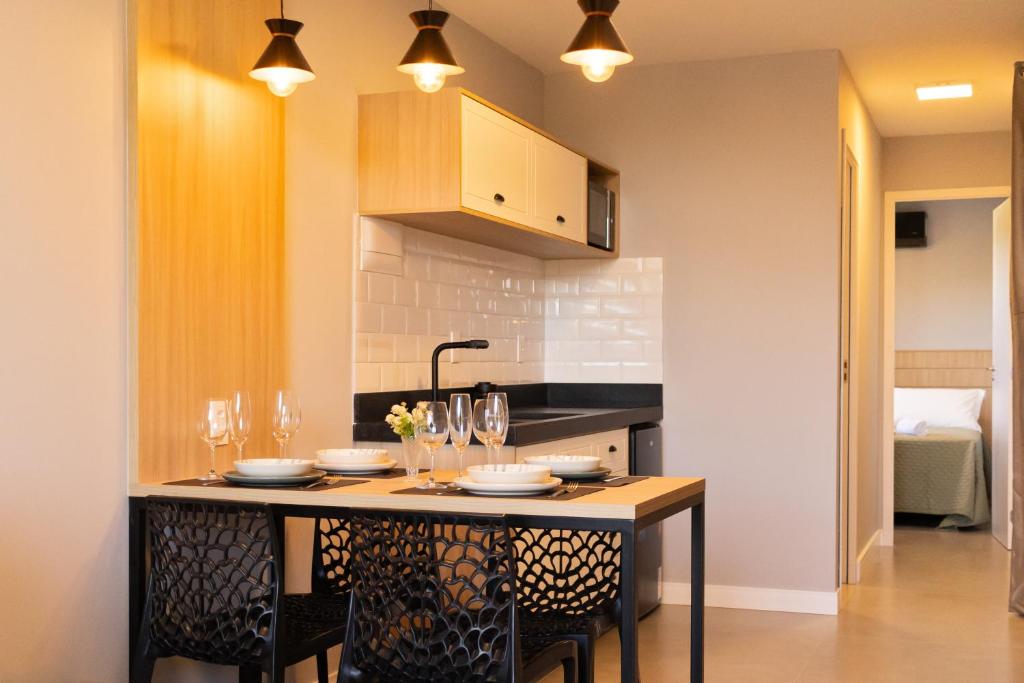 a kitchen with a table with plates and wine glasses at Eco Green Container- Guarda do Embaú SC in Palhoça
