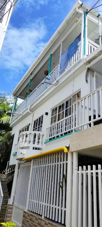 a white house with a white rail fence at Apartamentos Turísticos El Conquistador in San Andrés
