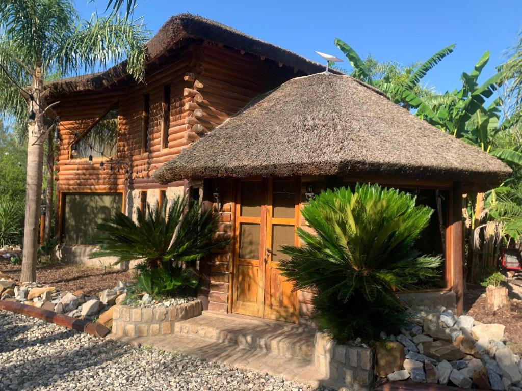 a log cabin with a thatch roof at Espacio Natural in Gualeguaychú