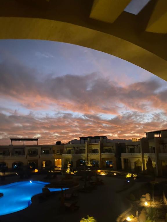 a view of a building with a pool at sunset at Sina Cave in Dahab