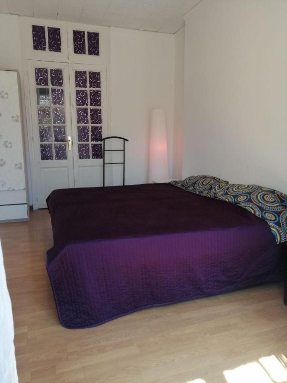 una camera da letto con un letto viola in una stanza di Sophia a Beausoleil