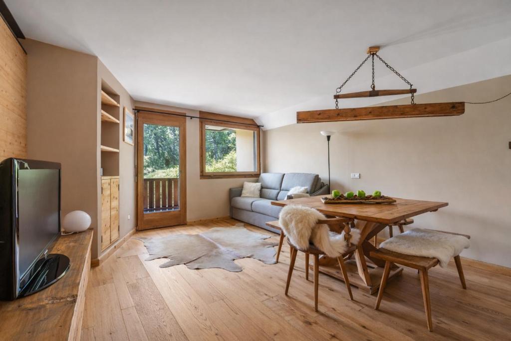 a living room with a table and a couch at Chic Wellness Apartment and Balcony in Maloja