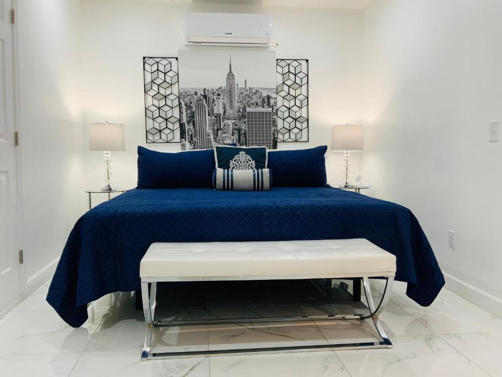 a bedroom with a blue bed and a bench at My Dream Space in Orange Park