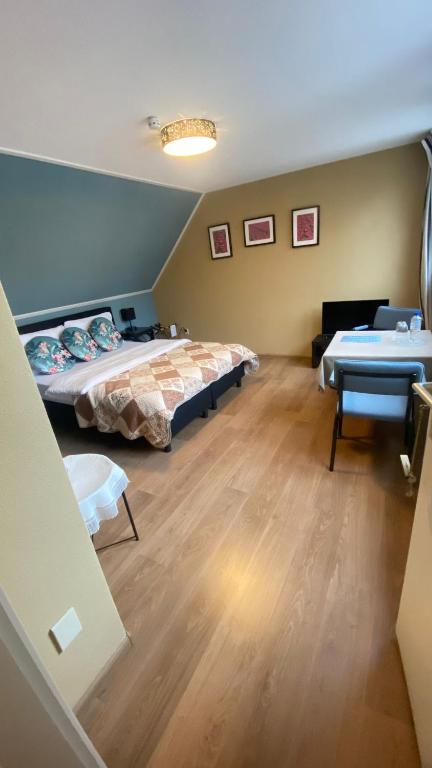 a bedroom with two beds and a table in it at De Drie Populieren in Losser