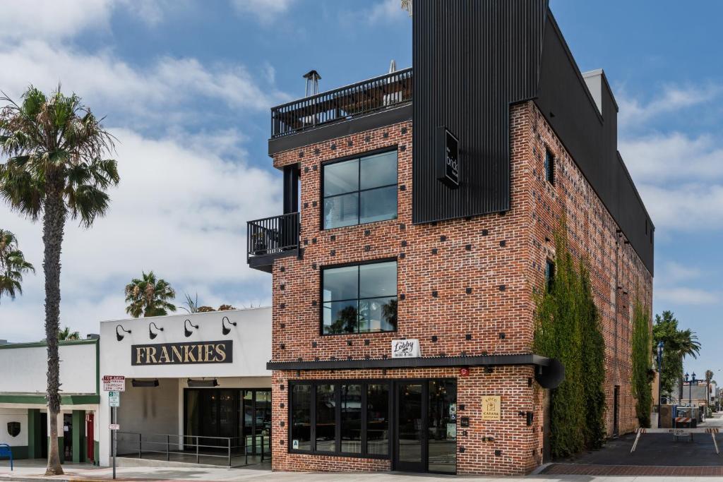 a brick building with a balcony on top of it at The Brick Boutique Hotel in Oceanside