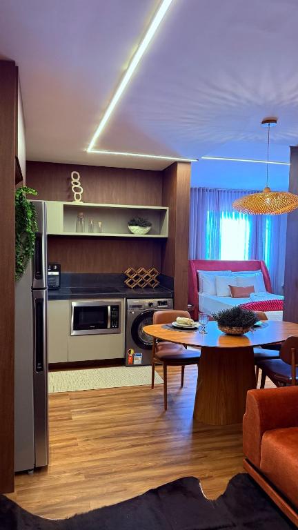 a kitchen and living room with a table and a couch at Flat Vinhedo in Montes Claros