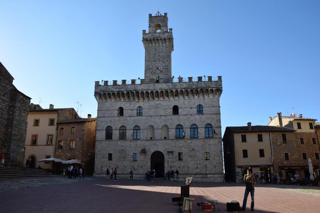 a building with a clock tower on top of it at Appartamento Talosa in Montepulciano