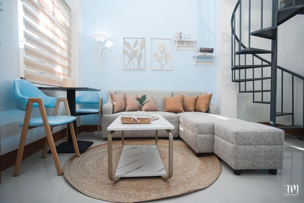 a living room with a couch and a table at Woodlands Condotel in Bulan