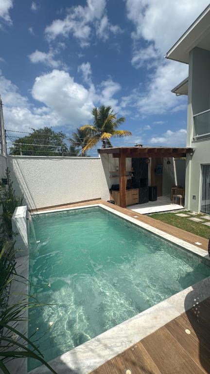 a swimming pool in front of a house at Casa Top in Porto Seguro