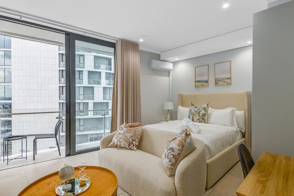 a bedroom with a bed and a couch and a window at The Solace in Midrand