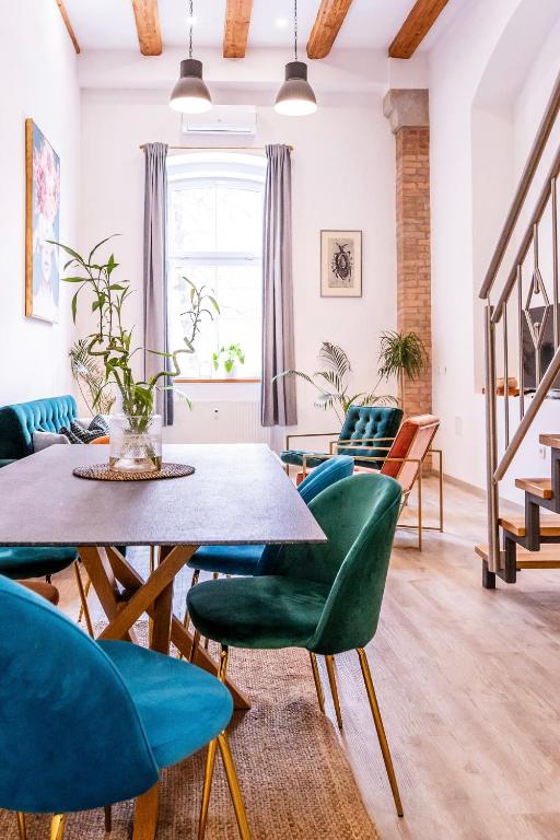 a living room with a table and green chairs at The LOFT Ljubljana in Ljubljana