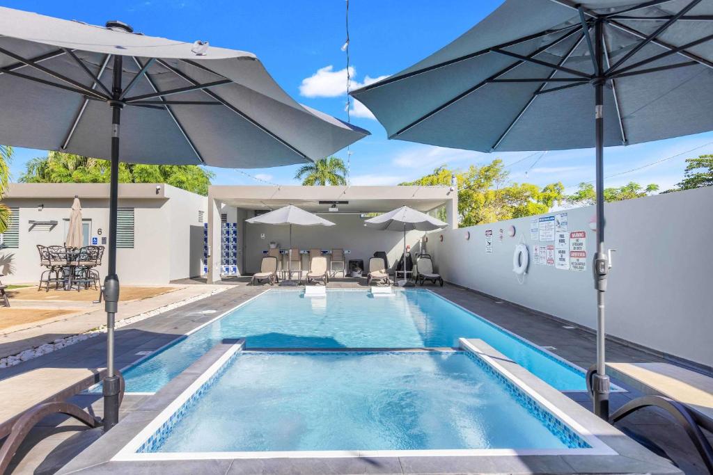 a swimming pool with umbrellas on a house at Aquaville Dorado Moderna Villa 3 in Dorado