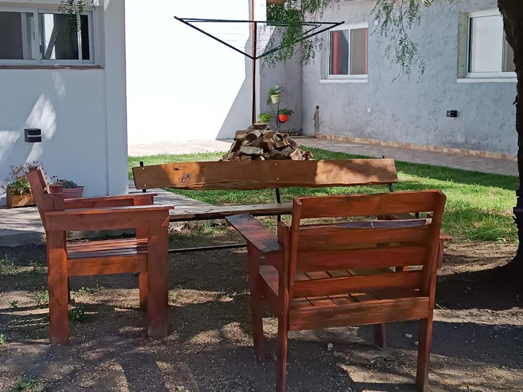 two wooden chairs sitting next to a table with a bench at Los Colibríes del Valle in Valle Hermoso