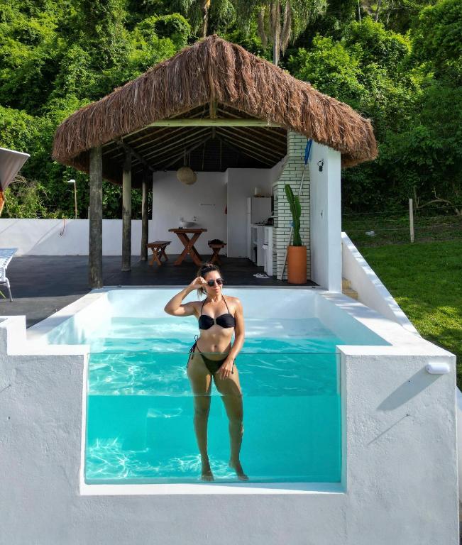 a woman in a bikini standing in a swimming pool at Cupulesantorini in Santa Isabel