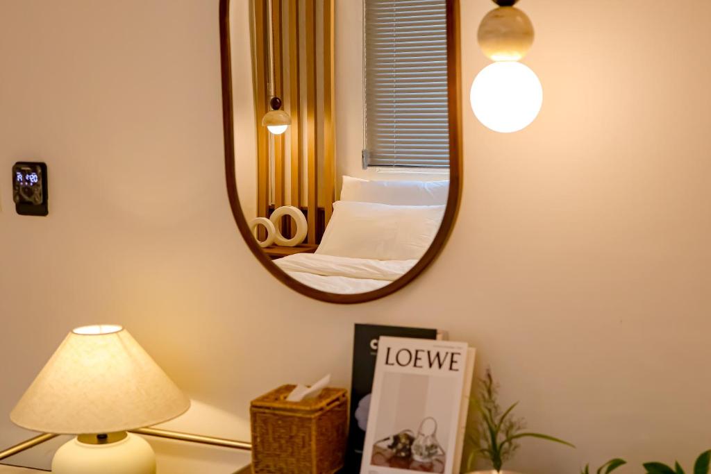a mirror in a room with a bed and a lamp at Sinnonhyeon Station 5minutes, Gangnam Plastic Surgery, Severance Hospital, COEX, airport bus 5minutes, Hongdae 30minutes, Itaewon 15minutes, 명동 30minutes in Seoul