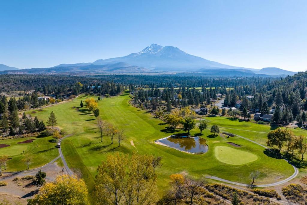 an aerial view of a golf course with a mountain in the background at Lake Shastina Golf Resort in Weed