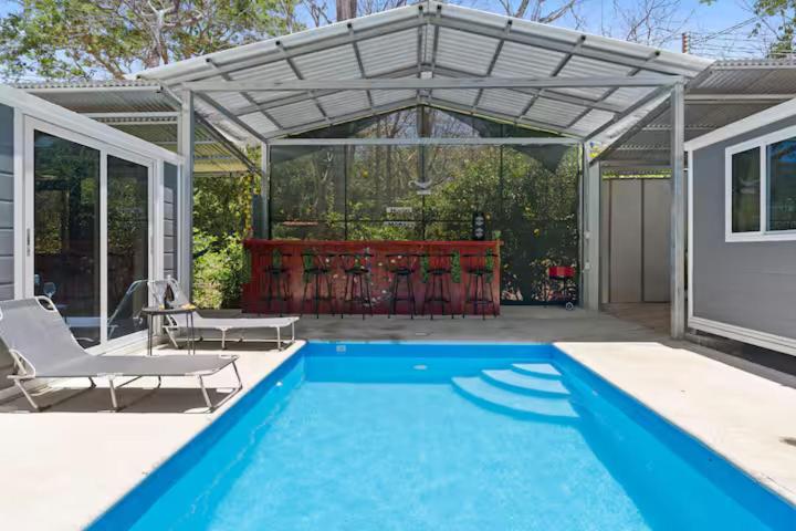 a swimming pool with a pergola and a swimming pool at Monkey Houses in Matapalo