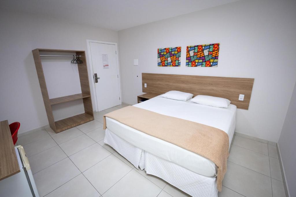 a bedroom with a large bed and a mirror at Hotel QualitySul in Teixeira de Freitas